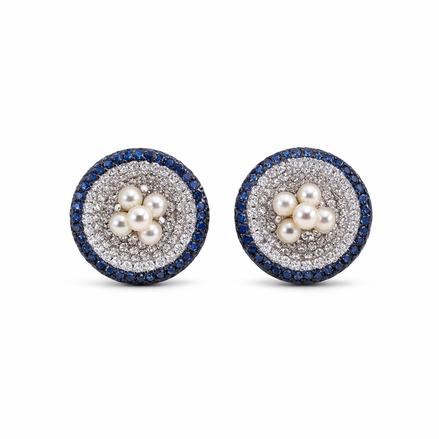 Round silver earrings, covered in white cubic zirconia stones. Freshwater pearls in the middle and blue zirconia halo on each earring.