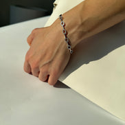 Hand wearing a bracelet on a neutral background