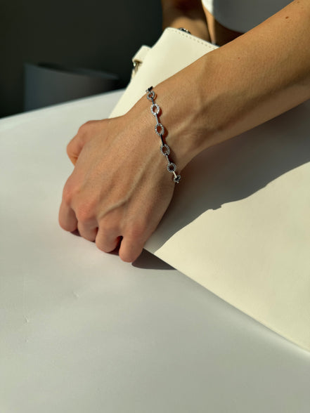 Hand wearing a bracelet on a neutral background